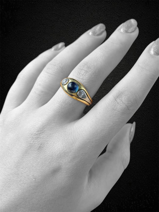 Anello a fascia in oro bianco con zaffiro cabochon e diamanti