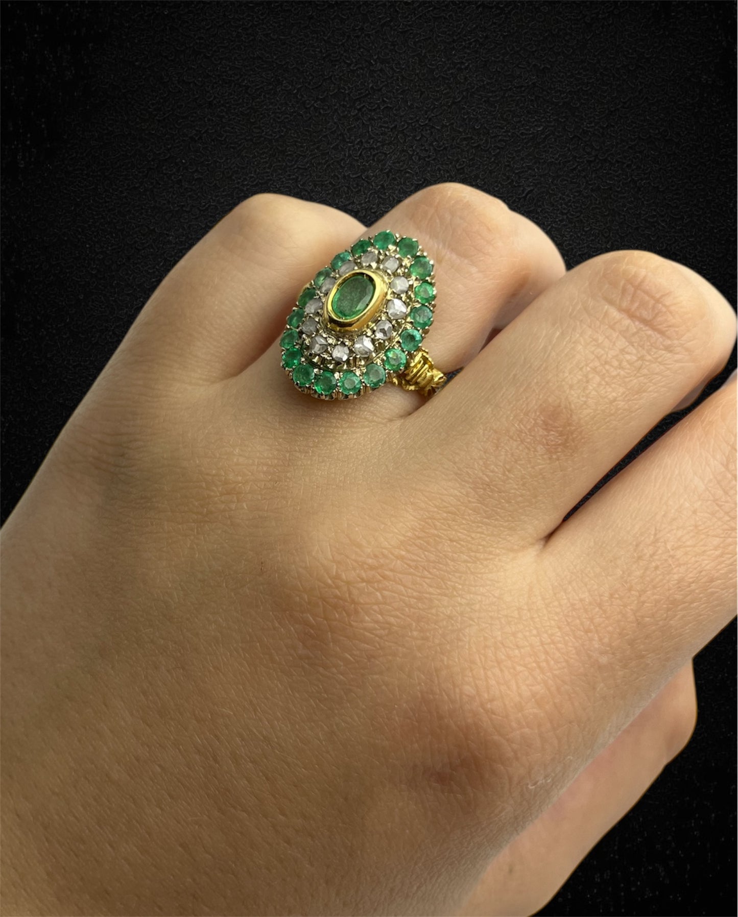 Anello in oro giallo con smeraldo ovale e contorno di diamanti e smeraldi