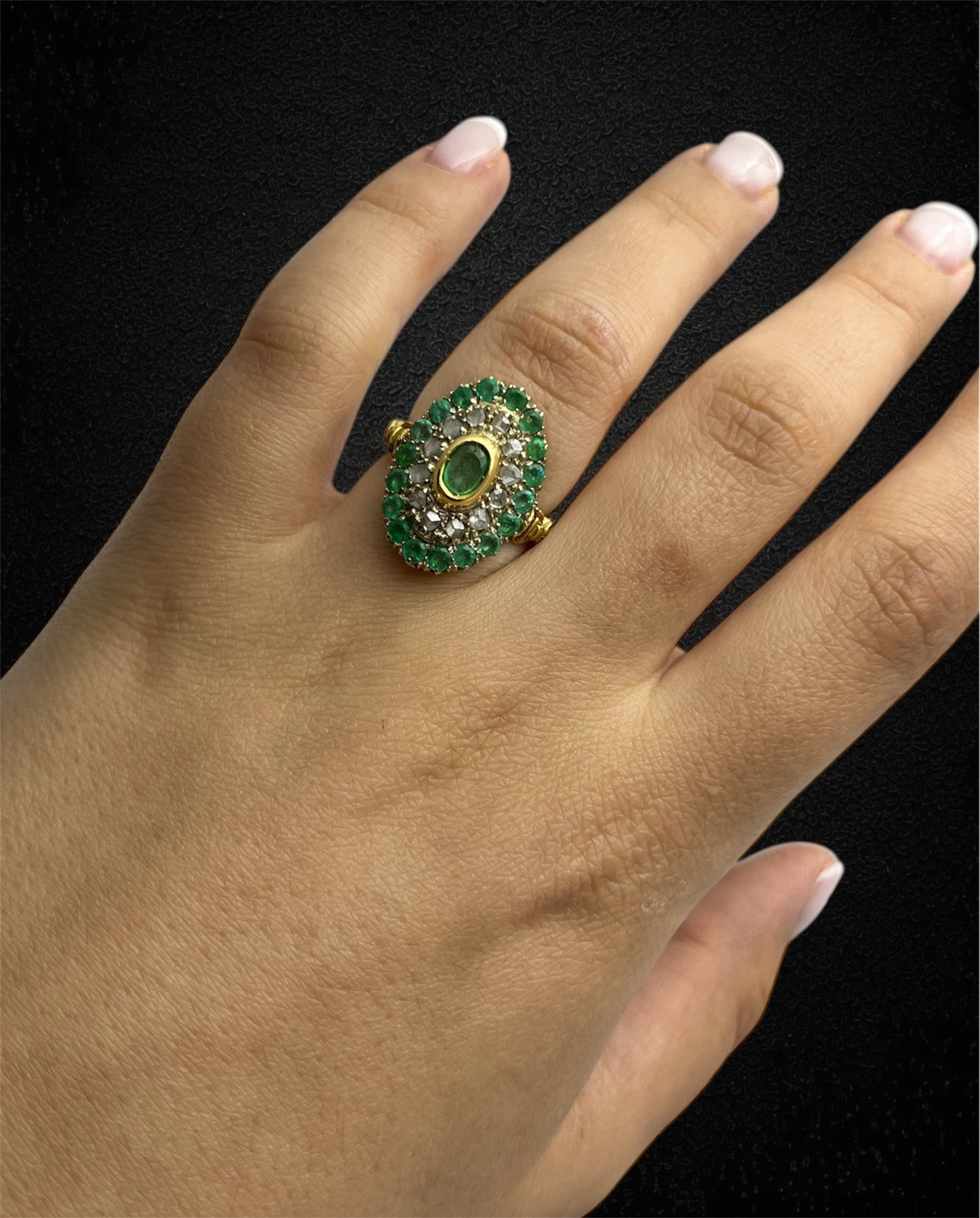 Anello in oro giallo con smeraldo ovale e contorno di diamanti e smeraldi