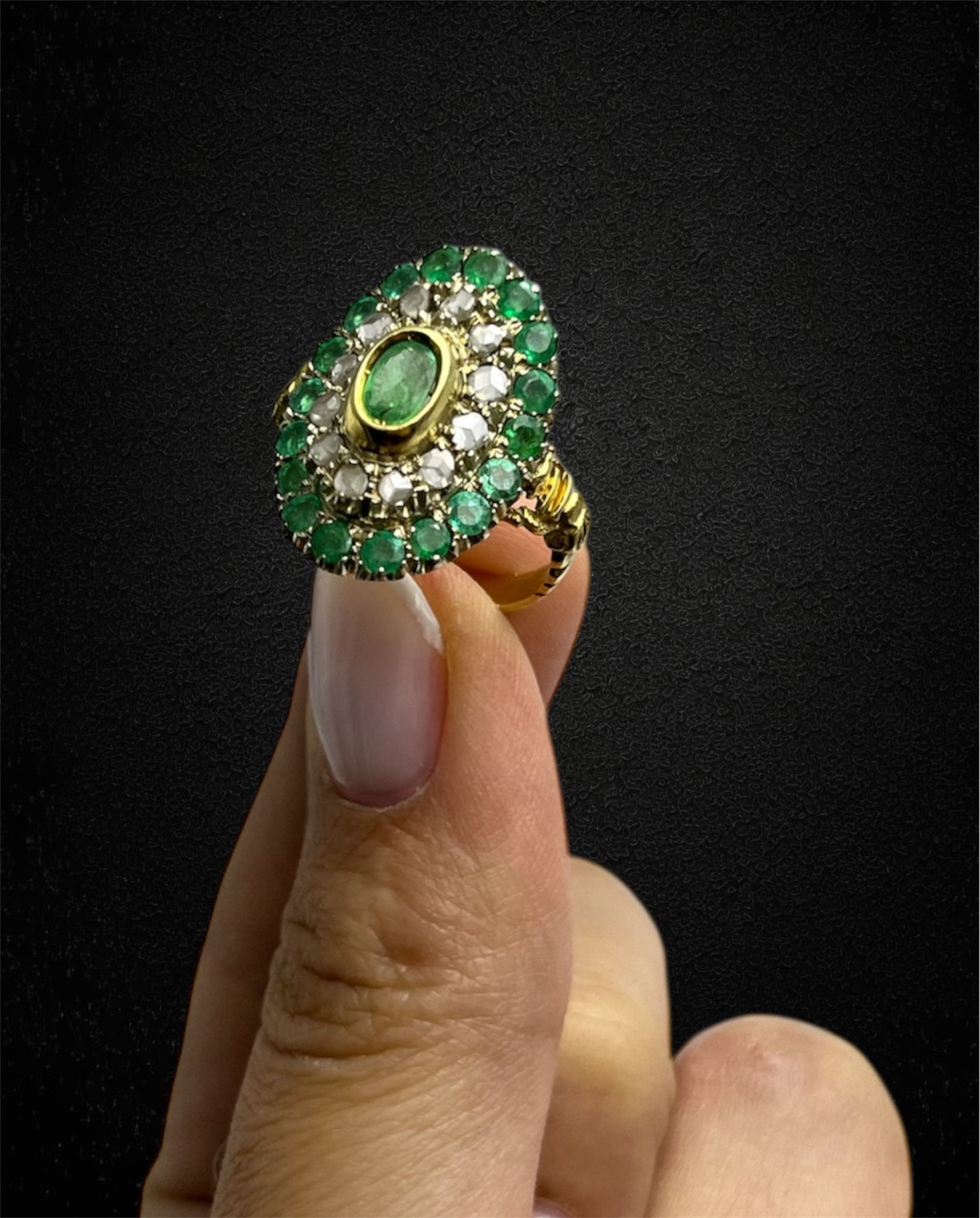 Anello in oro giallo con smeraldo ovale e contorno di diamanti e smeraldi