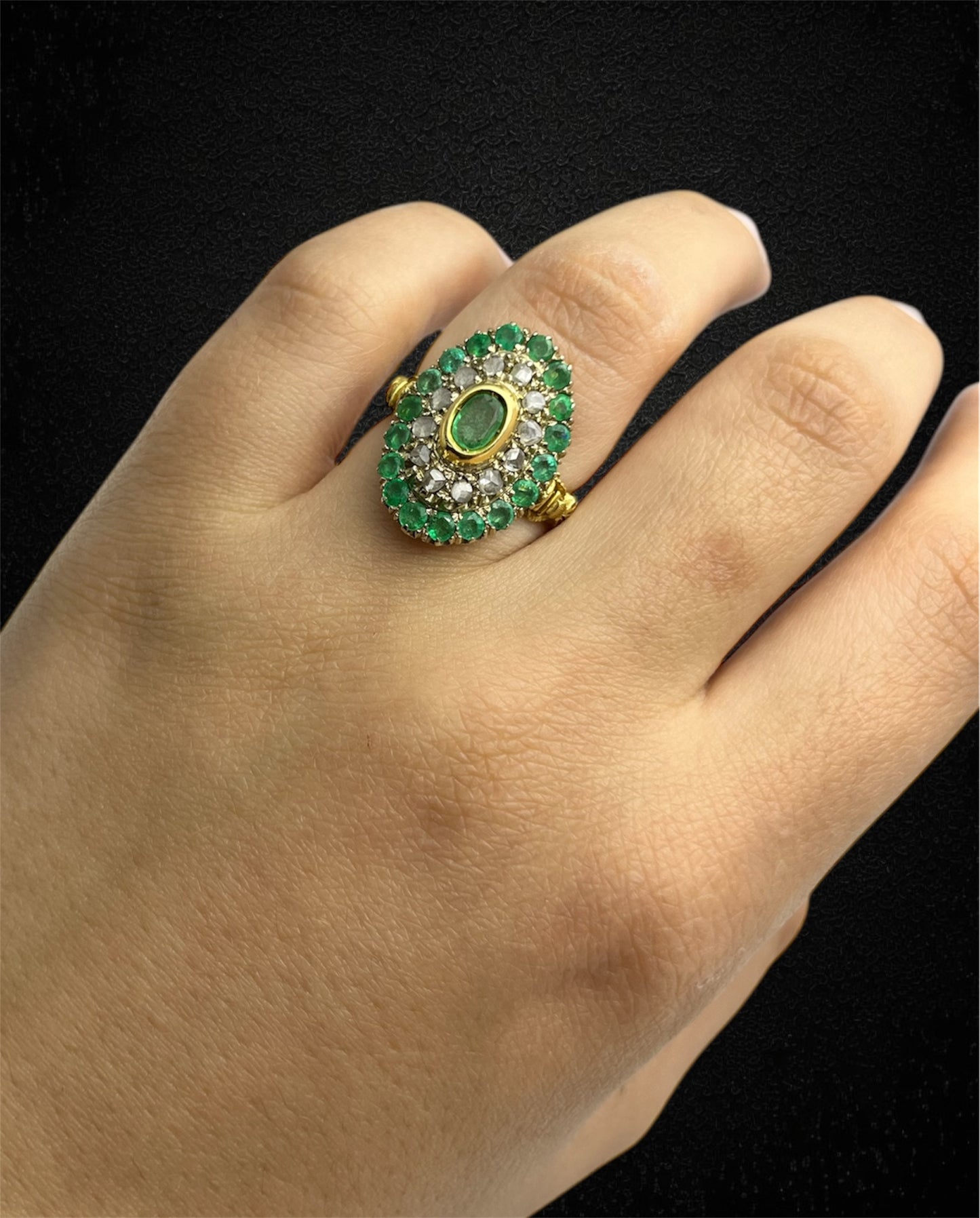 Anello in oro giallo con smeraldo ovale e contorno di diamanti e smeraldi