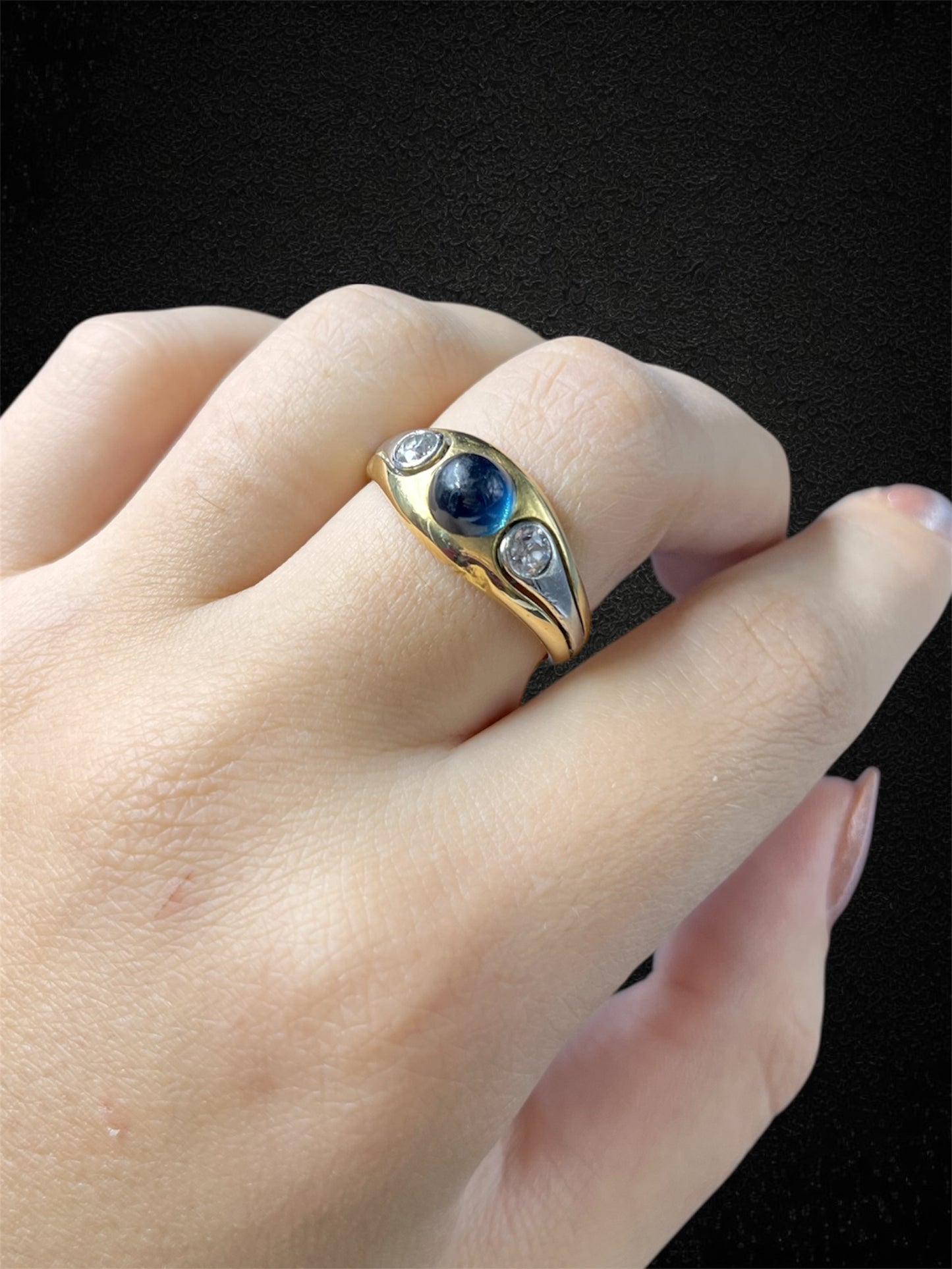 Anello a fascia in oro bianco con zaffiro cabochon e diamanti