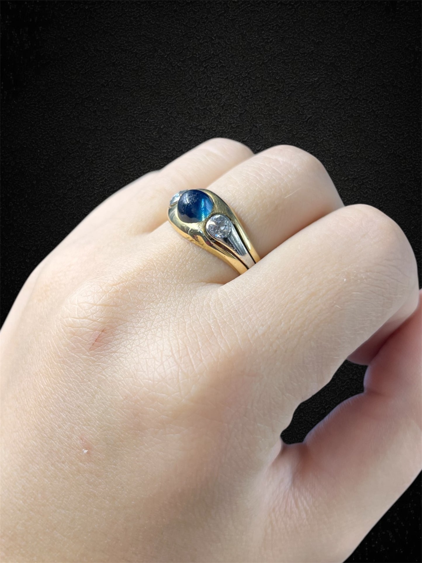 Anello a fascia in oro bianco con zaffiro cabochon e diamanti