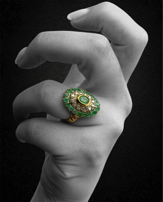 Anello in oro giallo con smeraldo ovale e contorno di diamanti e smeraldi